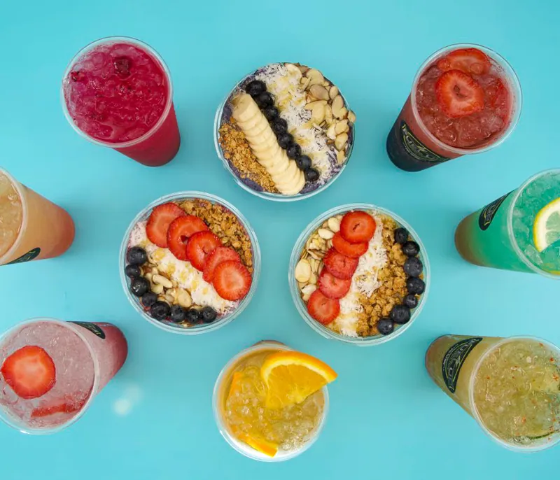 Colorful Fuel Up superfood bowls and refreshers arranged on a bright blue background