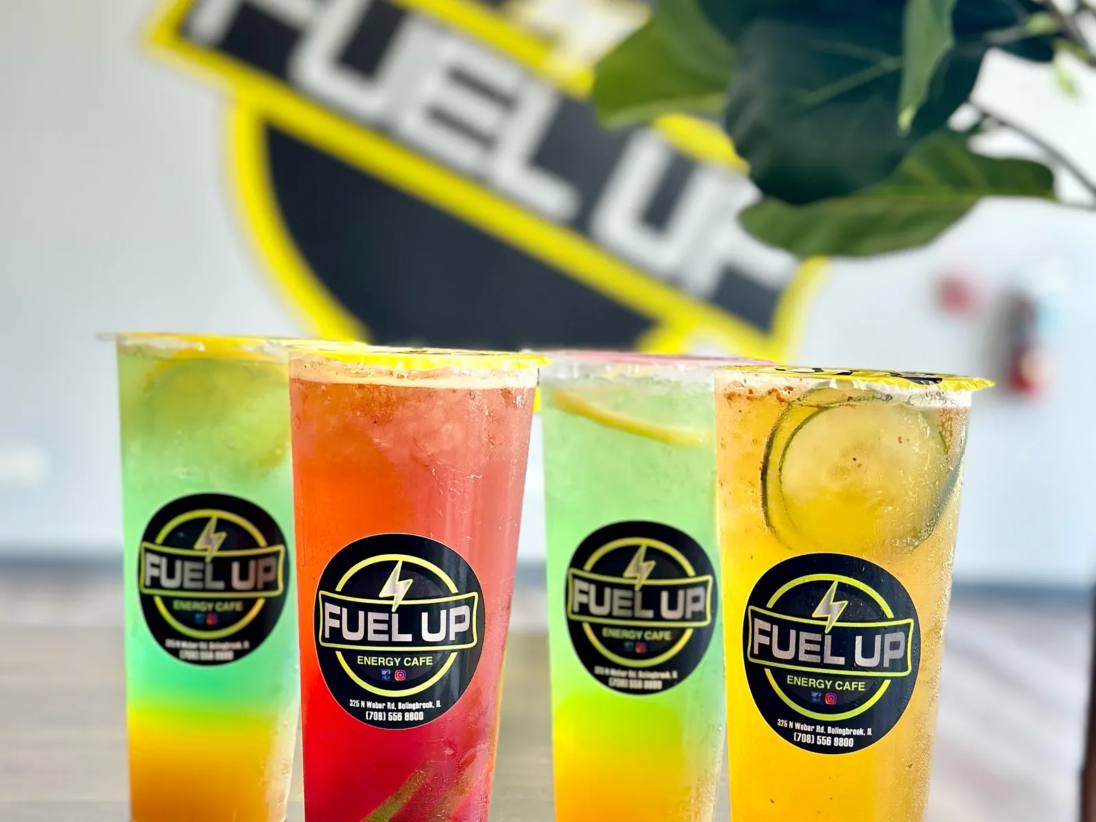 Four colorful LIT TEA energizing refreshers lined up in front of the Fuel Up logo