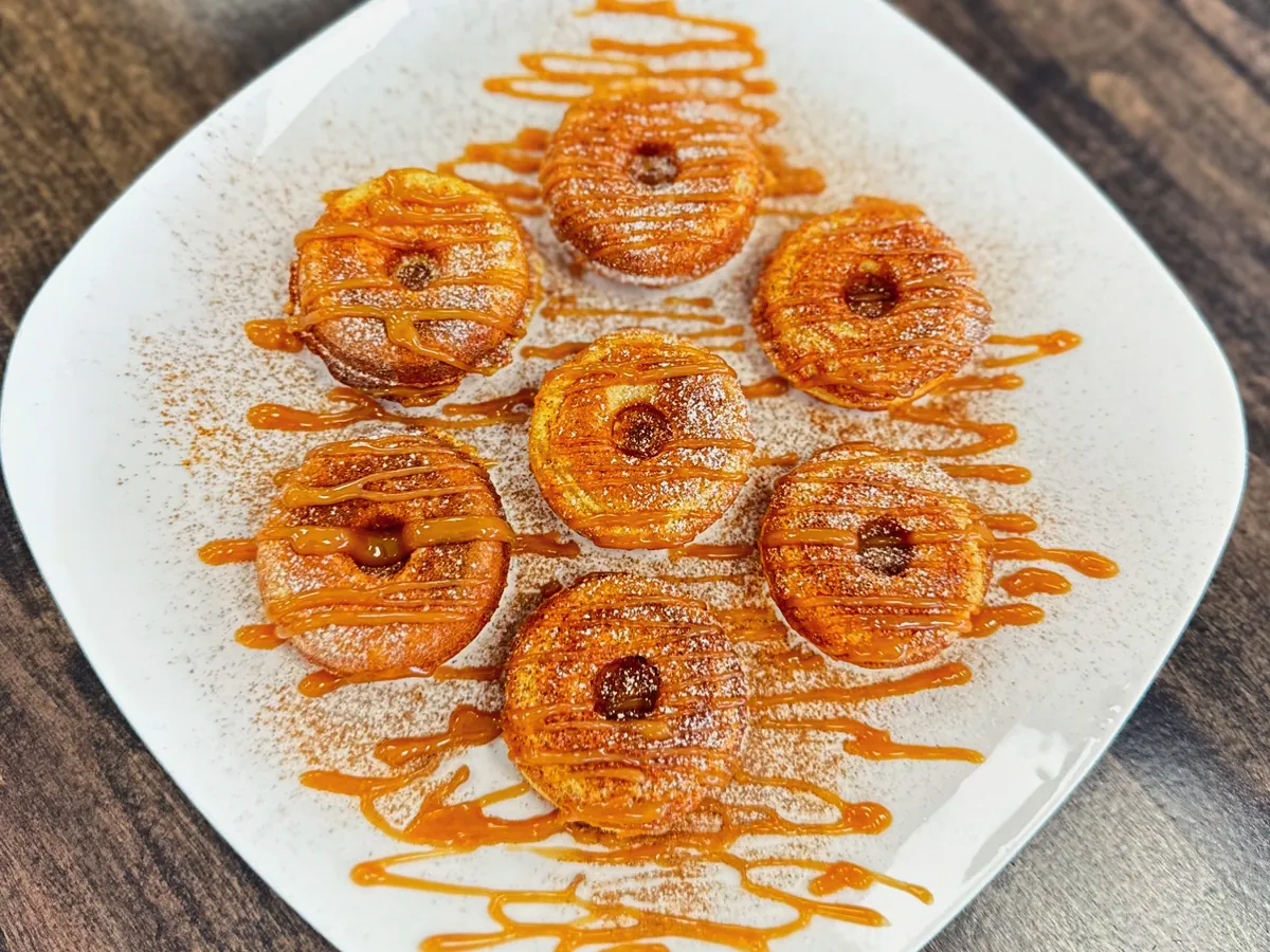Mini protein donuts with cinnamon and caramel drizzle on a plate